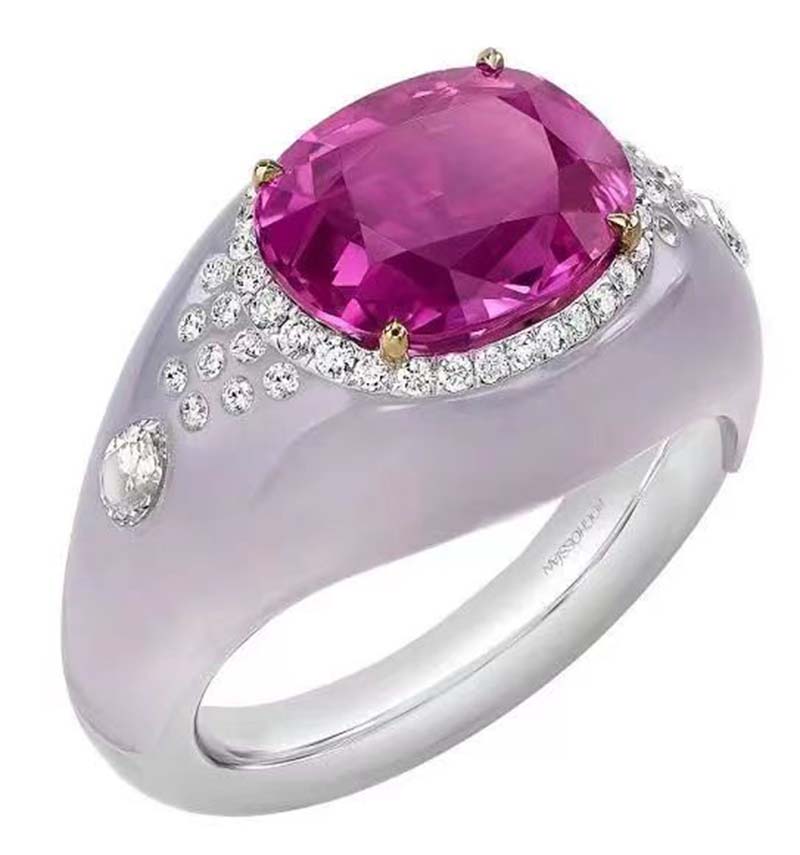 A cushion-shaped sapphire serves as the primary stone, an amethyst serves as the bottom stone, and a number of diamonds serve as embellishments